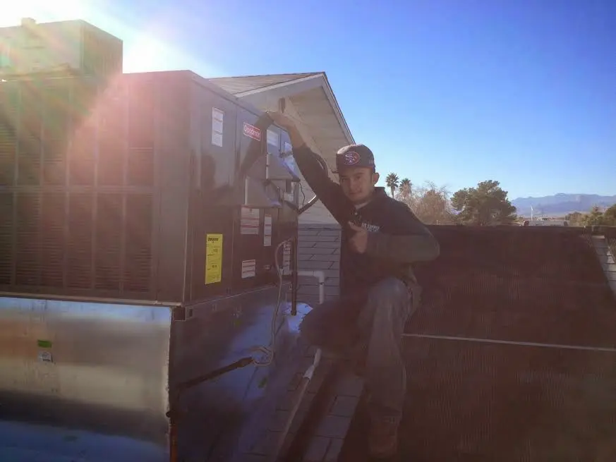 HVAC technician performing HVAC Inspection on a rooftop unit in Amherst